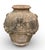 A striking and heavily weathered terracotta garden urn (or "orcia"), featuring rich Neoclassical relief carvings. This...