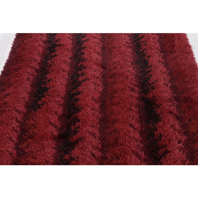 Hand-knotted in lush, high-pile wool in Sweden circa 1960-1970, this 5x7 vintage Swedish Rya rug is a bold new addition to...