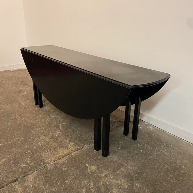Mid-century modern drop leaf dining table. The sides fold up and the legs swing out to create an oval dining table. Or...