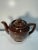 Vintage 1960s brown glazed ceramic teapot featuring an elegant gold floral design and fitted lid. Classic mid-century...
