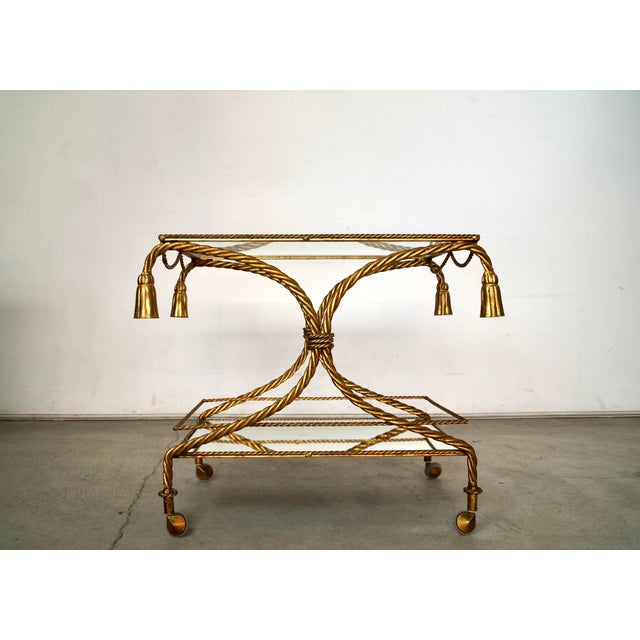 Vintage Hollywood Regency bar cart trolley for sale. It's made of metal, and displays incredible craftsmanship. It has a...