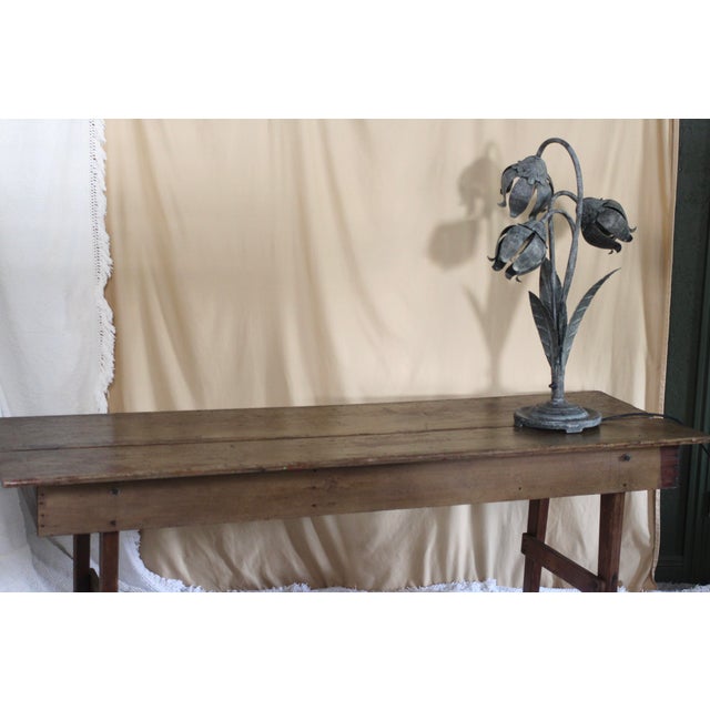 A tall and heavy lamp with 3 flowers that come from a circular base. Hollywood Regency style with a heavy base metal....