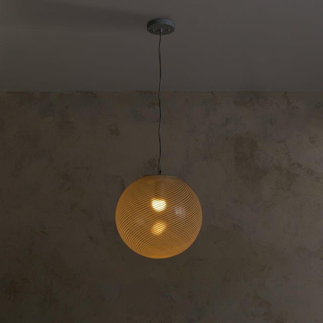 Sold and priced individually. A 1970s Italian pendant light, hand-blown in Murano glass. The spherical shade is etched...