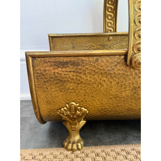 An English Regency brass firewood log holder with lion paw feet, circa early-20th century. Please see condition details...