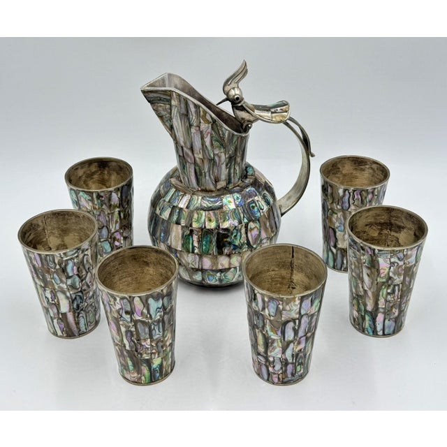 An exceptional Mid-Century Modern Mexican Alpaca silver and natural abalone shell beverage service consisting of a...