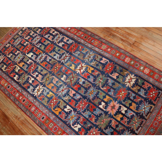 An early 20th century Caucasian Karabagh rug featuring a non-traditional motif in lively colors. The field is navy, green...