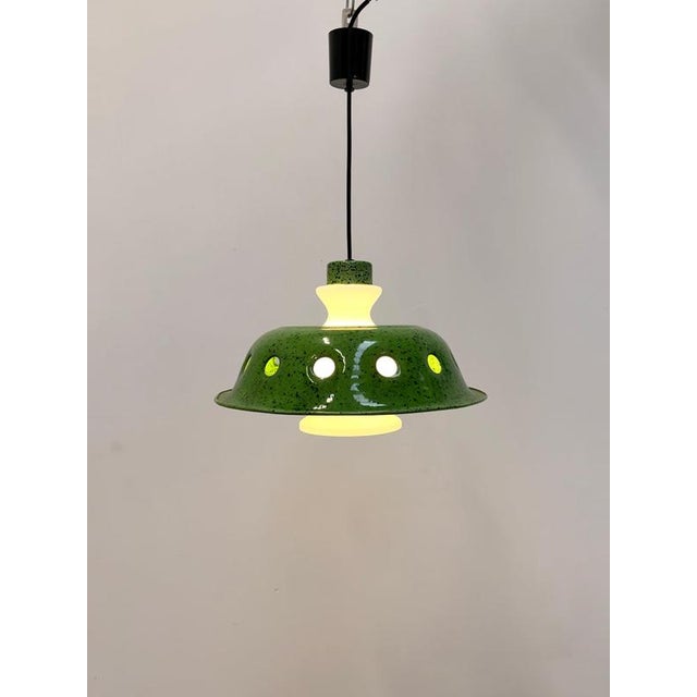 Striking vintage pendant lamp featuring a bold green enamelled metal shade with a characteristic black speckled finish....