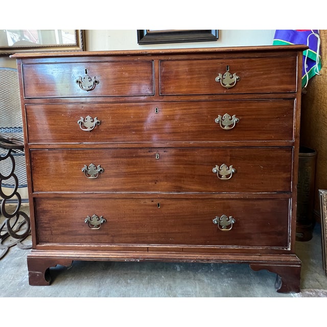 Stunning 19th century 5-drawer Georgian chest of drawers crafted of mahogany and featuring decorative brass pulls. 43"w x...