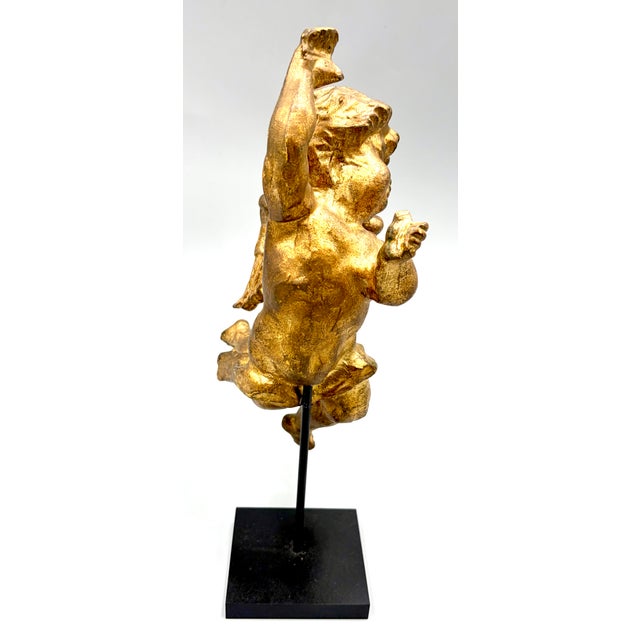 Antique French gilded wood cherub putti sculpture fragment on a stand. This beautiful sculpture has fine details in a...
