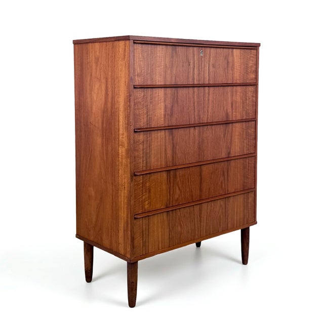 Vintage 5-Drawer dresser crafted in teak with conical teak legs and dove-tailed drawers. Made in Denmark.