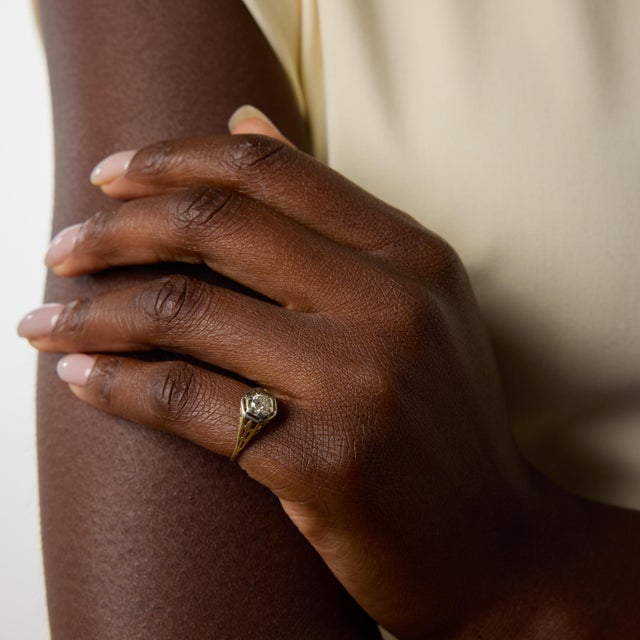 A delicate engagement ring from the Art Deco era, this elegant two tone design centers on a sparkling old European cut...