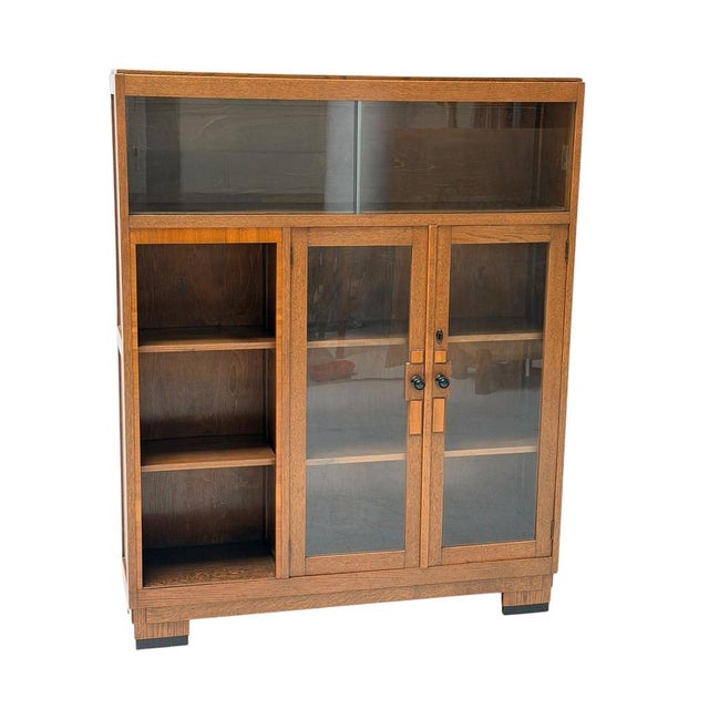 Stunning and elegant Art Deco Modernist bookcase with glass sliding doors on top. Striking Dutch design from the 1930s....