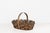 Vintage oval-shaped splint woven gathering basket featuring a solid wood base, and an arched wood handle. The sides are...
