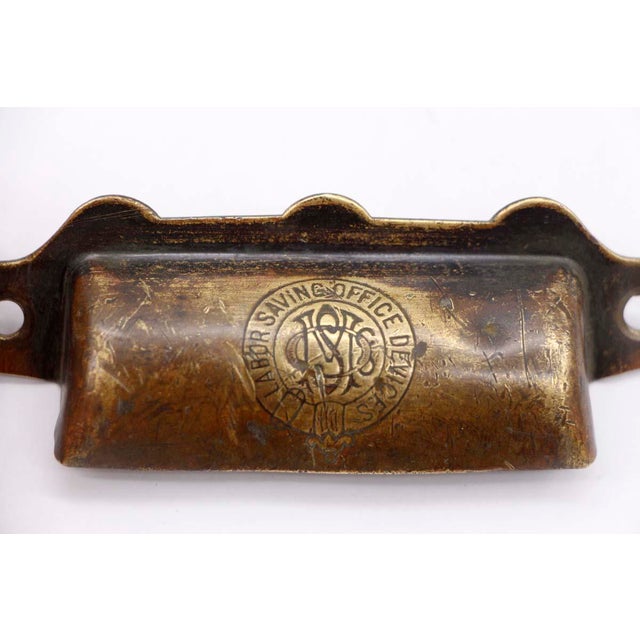 Antique brass bin drawer pull stamped "Labor Saving Office Devices". The original mounting screws are not available. Good...