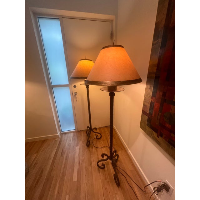 Pair of Dennis & Leen roped iron floor lamps with large bobeche and waxed candle holds one 3-way socket. The finish is...