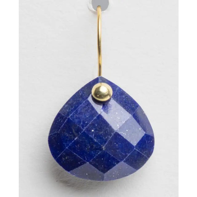 A pair of cushion cut, pear-shaped lapis lazuli drop earrings with 18K gold ear wires. For pierced ears. The fine jewelry...