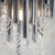 Modern floor lamp on a conical metal base with straight stem. The light fitting comprises cylindrical rods of varying...