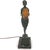 DETAILS An antique figural table lamp of a standing young girl in patinated bronze holding an amber Daum glass urn....
