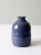 This is a vintage studio pottery vase. The handmade vase features a rich blue glaze with lipped bottleneck.