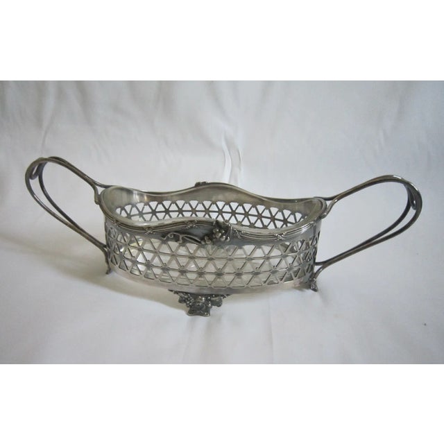 Gorgeous Art Nouveau silverplate Epergne. Fluid lines with separate glass insert. It measures 12"W x 4.25"D x 4"H and is...