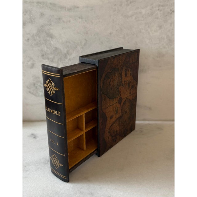 Vintage wooden box made to look like a book with hidden jewelry storage with orange velvet lining and atlas map design on...