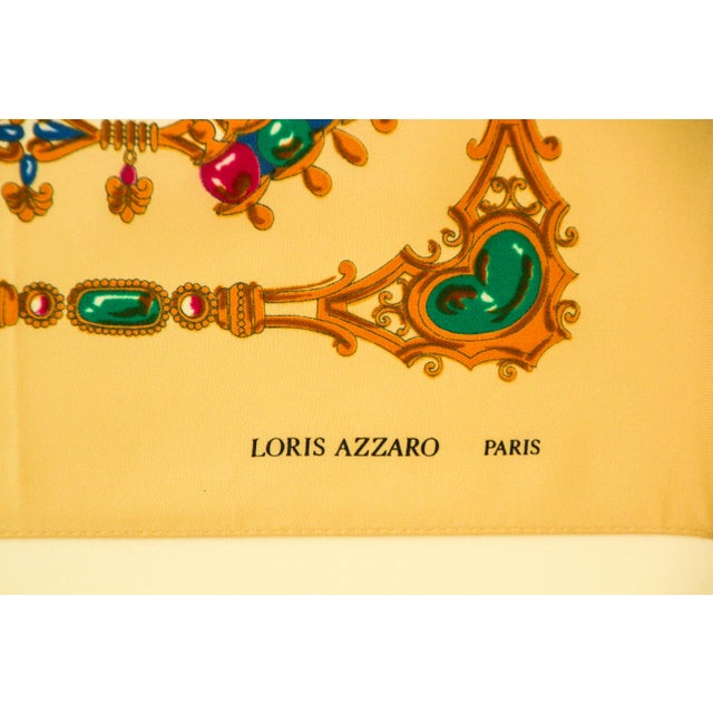 Beautiful 80's Loris Azzaro silk scarf in light colors of gold, beige, emerald green, ruby red, blue and browns. This...