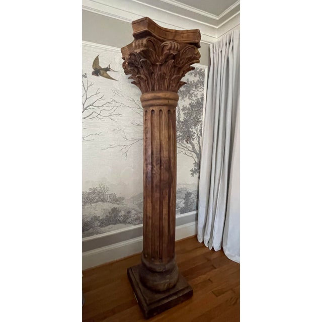 An antique solid wood carved corinthian column out of a single tree log. Extremely heavy. The patina and color of the wood...