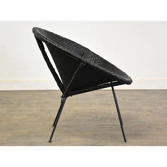 A mid century modern black wicker cane lounge chair with black iron base. Seat height is 14.5”. 27” wide. 25.5” deep....