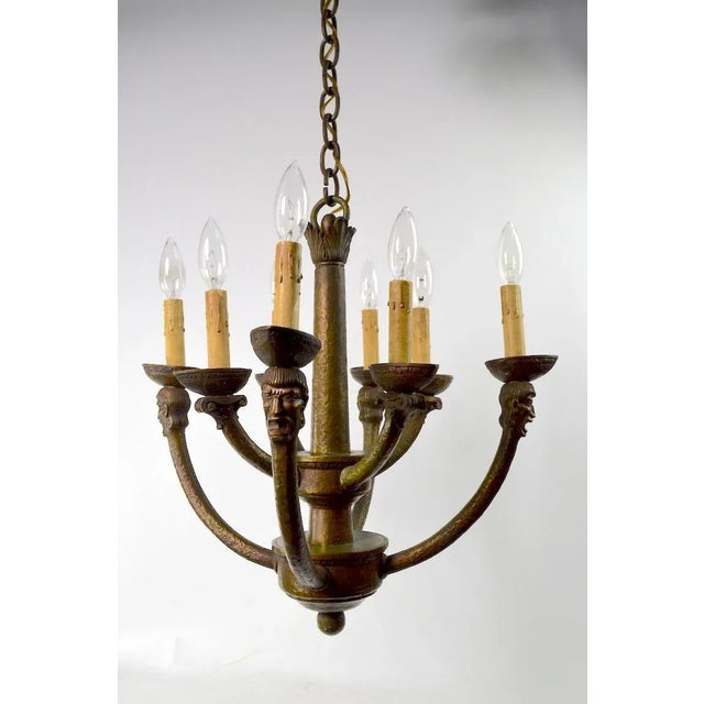 Wonderful cast bronze eight-light Gothic Mission chandelier having male heads on the outer arms, and column capitals on...