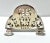 A 1950s English silverplate napkin holder by I.F.S. Ltd., featuring ornate pierced openwork and a gracefully arched...