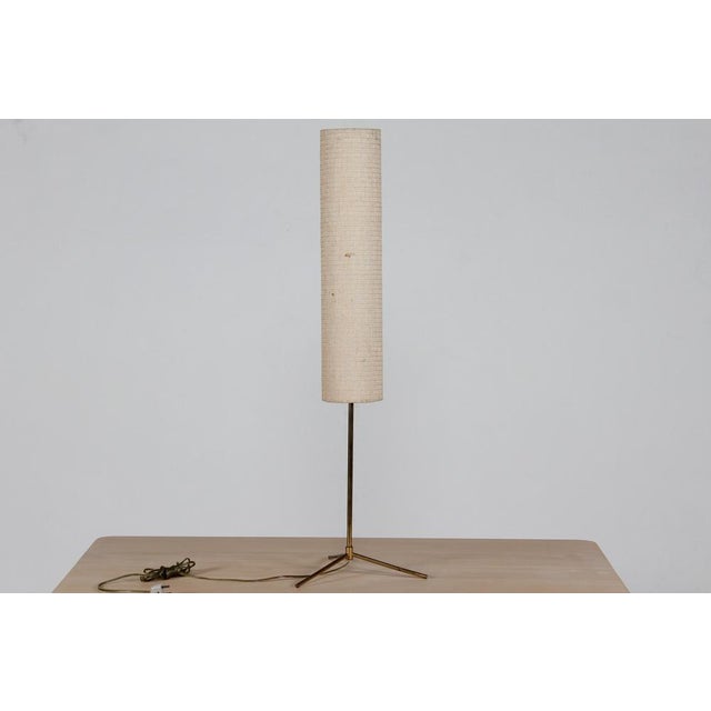 Vintage table lamp with long slim cylindrical woven shade made in Denmark in the 1960s. The lamp base is made of brass...