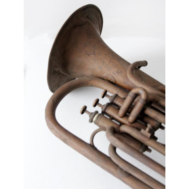 This antique baritone horn is marked “Beau Ideal, Chicago,” a Lyon & Healy brand from the late 19th to early 20th century....