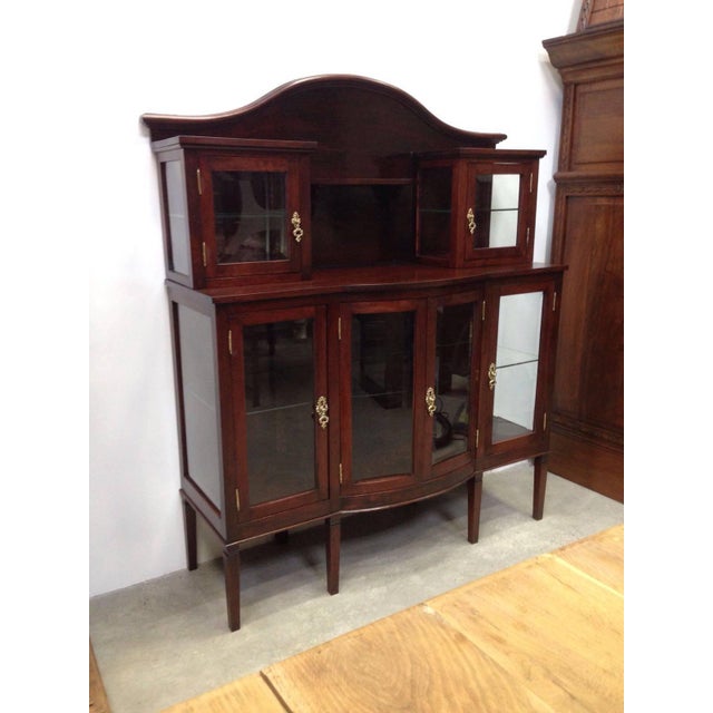Modernist mahogany buffet with crest. Grand buffet made of mahogany. Glass cabinet doors on either side above side...