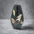 A refined example of Japanese Takaoka metalwork, this mid-century vase presents a classic tapered silhouette adorned with...