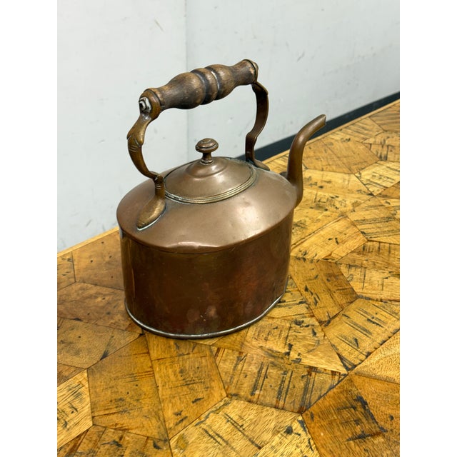 Design Plus Gallery presents a 19th Century Victorian Era Copper Kettle + Wooden Handle, showcasing period utility and...