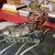 Red haired sphinx lounging on top of blue and gold leaf base. Made of plaster