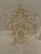 Elegant framed textile artwork by Trowbridge, featuring an intricate symmetrical motif worked in alternating gold- and...