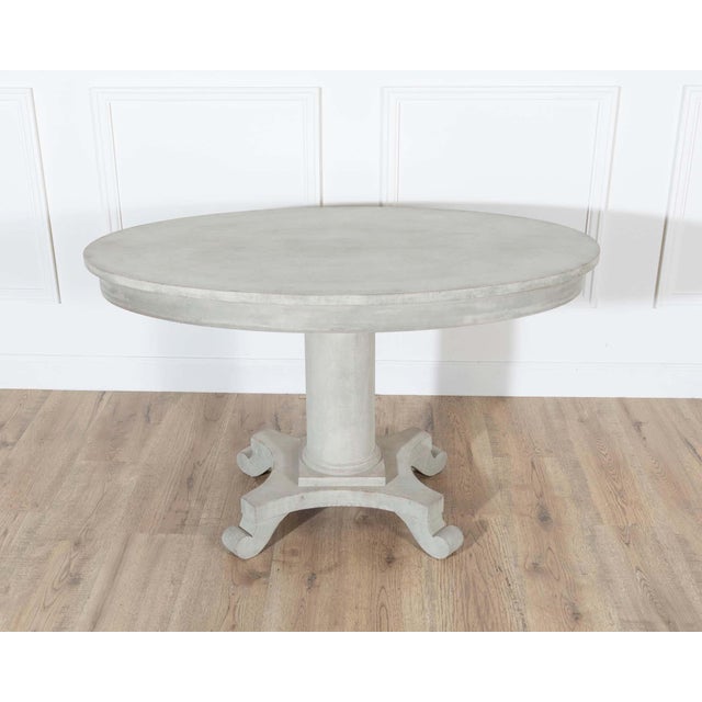 A Swedish oval center table from the early 20th century, circa 1900–1910, painted in a soft blend of green and grey that...
