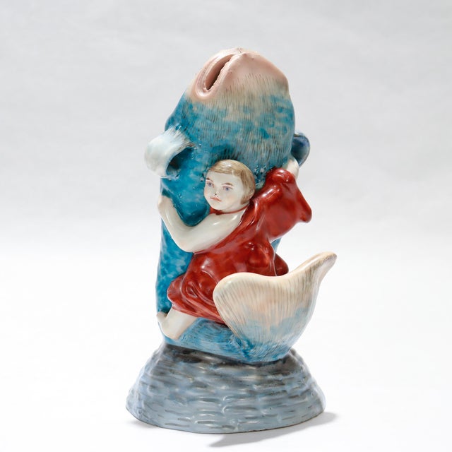 A fine vintage Japanese porcelain figurine or okimono. Depicting Kintaro (金太郎) wrestling a giant catfish or koi fish....