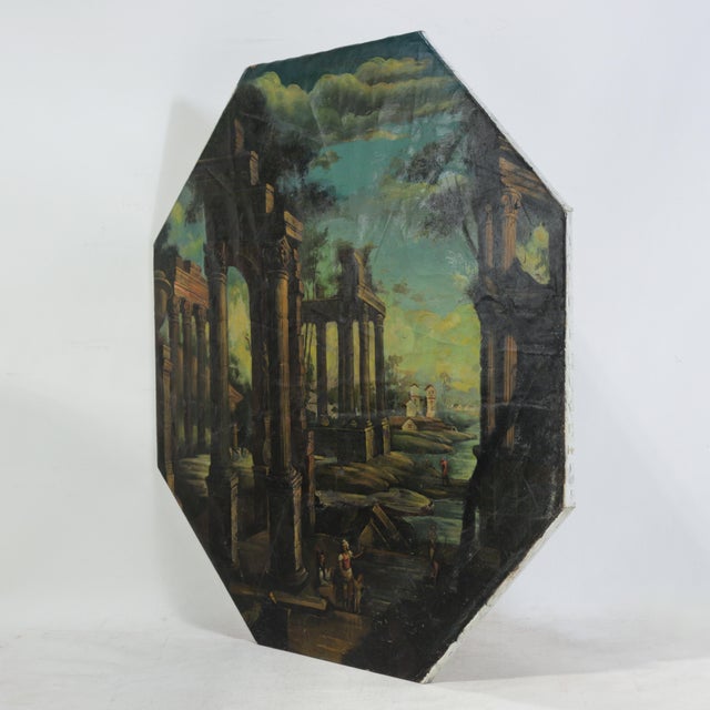 This striking vintage octagonal oil painting depicts a dramatic classical capriccio landscape, featuring soaring Roman...