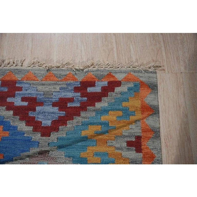 This multicolor jewel tone rug is crafted from wool using a durable flat weave technique. It represents a Kilim style...