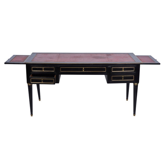 This black ebonized directoire style desk includes brass detailing, red leather and original keys. France, circa...
