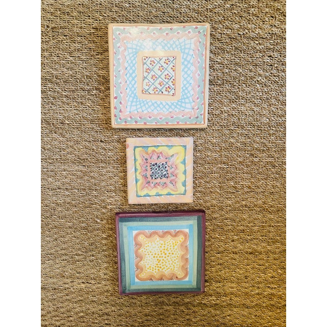 Set of three hand-painted decorative wooden plaques featuring whimsical folk art geometric and floral motifs in soft...