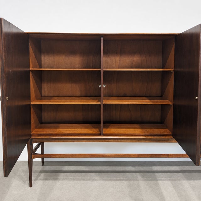 Vintage Scandinavian highboard made in Denmark , displaying a rich and expressive wood grain. The cabinet combines...
