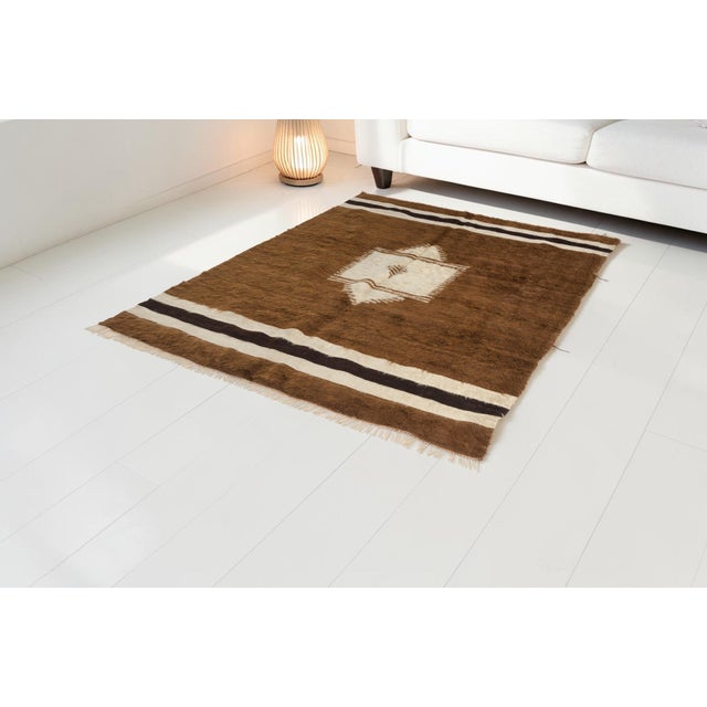 This is a vintage Turkish Oushak rug from the Mid 20th Century. The piece was hand-knotted.