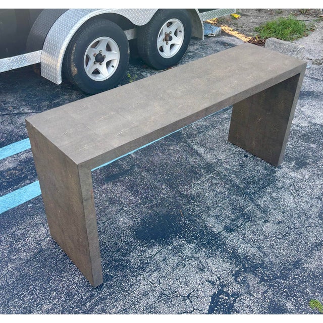 A striking 1980s vintage modern console table fully clad in textured faux shagreen panels with a sophisticated grey tonal...