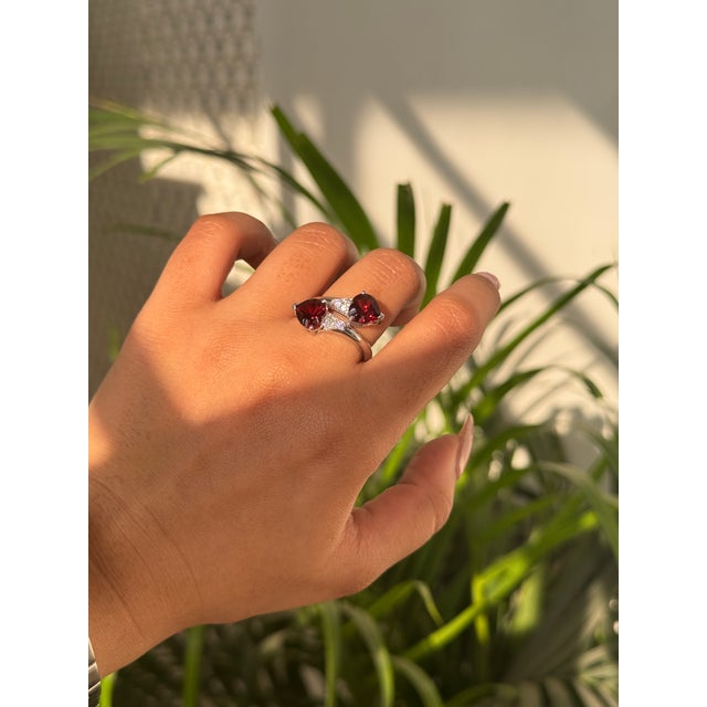 This eye-catching romantic victorian style ring showcases two vibrant heart-shaped natural deep red garnets with a...