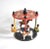 A vintage, hand-made toy in the form of a spinning carousel with two children in seats and two children riding horses. The...