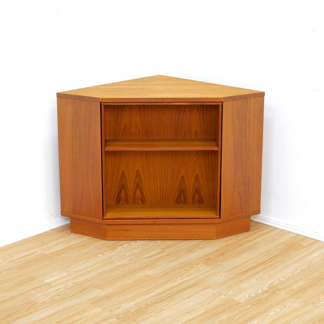 This fabulous mid century corner bar cabinet was manufactured by Vildbjerg Mobelfabik in Denmark during the 1970s....