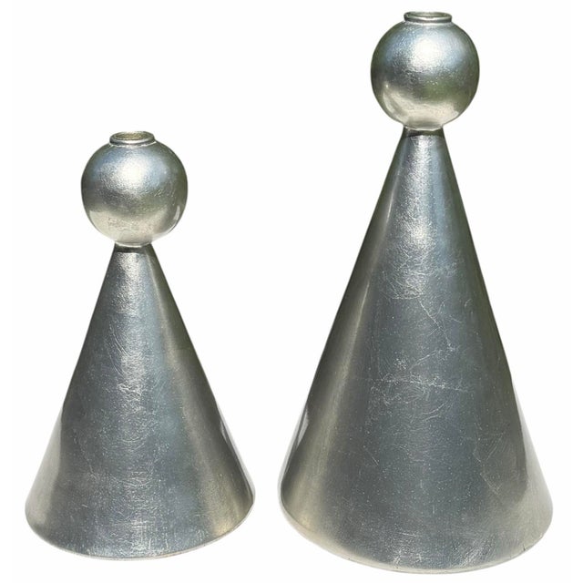 A striking graduated pair of sculptural ceramic candleholders with bold conical forms topped by rounded spherical...
